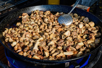 Large portion freshly cooked deep fried pork meat, displayed for sale at a street food market in Bucharest, Romania
