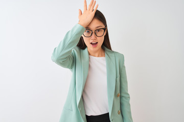Chinese businesswoman wearing elegant jacket and glasses over isolated white background surprised...