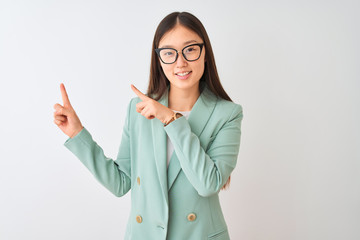 Chinese businesswoman wearing elegant jacket and glasses over isolated white background smiling and looking at the camera pointing with two hands and fingers to the side.