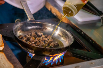Cooking snails in a frying pan with fire in restaurant, Prague, Czech Republic