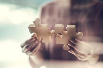 Closeup hand of woman connecting jigsaw puzzle with glass foreground, Business solutions, success...