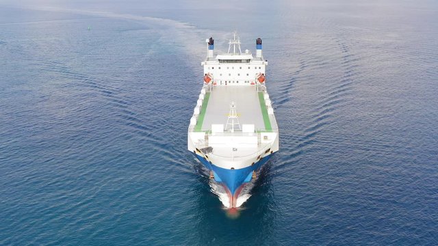 Aerial follow footage of a Large RoRo (Roll on/off) Vehicle carrier vessel cruising the Mediterranean sea.