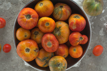 brown tomatoes with drops of water on a concrete background