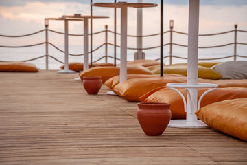 Straw umbrellas and pillows on the seashore pier.