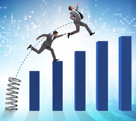 Business people jumping over bar charts