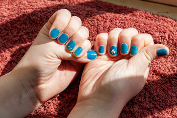 Vibrantly painted blue fingernails