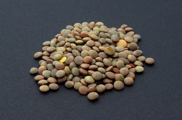 Brown lentils on an isolated black background