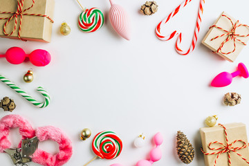 Christmas or New Year composition with a variety of pink sex toys and decoration on white...