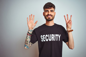 Young safeguard man with tattoo wering security uniform over isolated white background showing and...