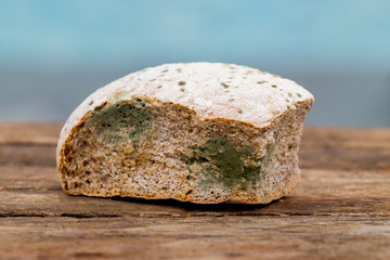 Moldy bread on a blue blurred background, spoiled food_
