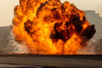 Foto op Canvas Massale brandexplosie of staking in militaire gevechten en oorlog. Voertuigexplosie uit een tank in een stad in het Midden-Oosten. Militair concept. Kracht, kracht, explosie. © KingmaPhotos