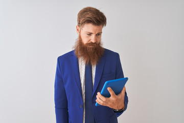 Young redhead irish businessman using tablet over isolated white background with a confident...