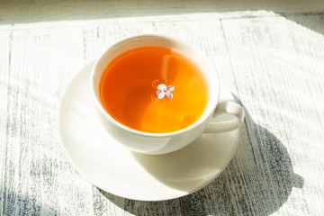 Cup of herbal tea on wooden background. Rays of sunlight - Image
