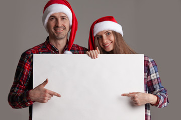 Couple in Santa hats with banner