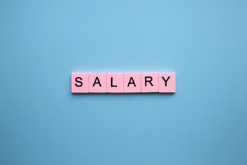 Salary word wooden cubes on blue background