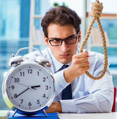 Unhappy businessman thinking of hanging himself in the office