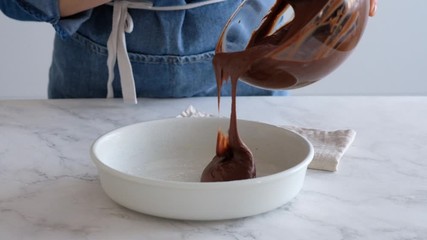 Woman chef makes dessert in her kitchen. Chocolate mold filling. Brownies.