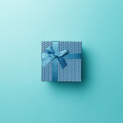 Blue gift box with blue ribbon on blue background. Top view. Flat lay. Copy space. Colorful background. Minimal christmas new year creative concept. AI Aqua - trendy color of the year 2021