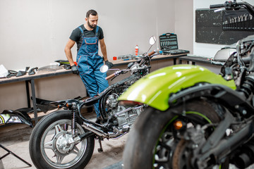 Obraz na płótnie Canvas Biker with motorcycles in the garage