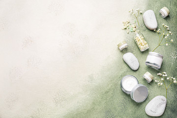 Cosmetic cream with spa items on color background