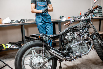Fototapeta na wymiar Vintage motorcycle with worker at the workshop