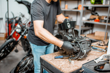 Man repairing motorcycle engine