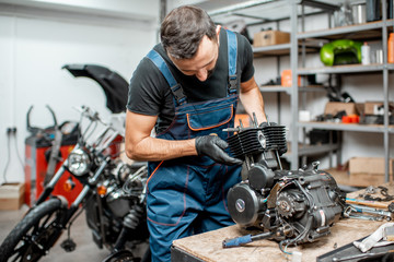 Obraz na płótnie Canvas Man repairing motorcycle engine