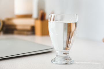 Glass of fresh water on table in room