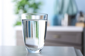 Glass of fresh water on table in kitchen