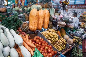 Organic tropical exotic fruits on display in a traditional market in Managua, Nicaragua. Food store. Bananas, cucumber, guavas, granadilla, tomatoes, passion fruit. Organic food. 