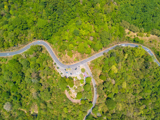Aerial view of cars driving on curved, zigzag road or street way path on mountain hill with green...