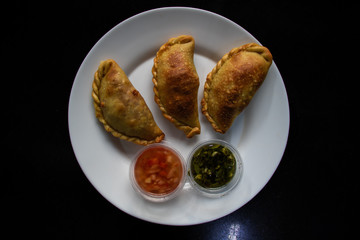 Empanadas with chimichurri and argentinian salsa top view