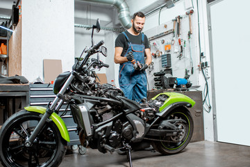 Obraz na płótnie Canvas Biker with motorcycle in the garage