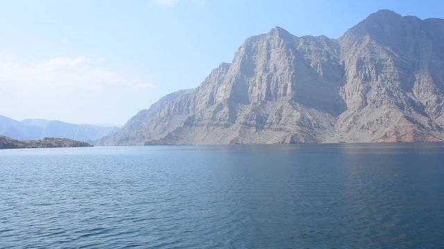 Blue waters of Musandam, Oman on a Dhow Boat trip in the Middle East the fjords, rocky mountains, and blue water near Strait of Hormuz 