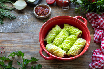 savoy cabbage rolls stuffed with meat, rice and vegetables on a rustic table