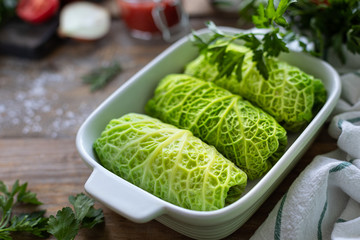 savoy cabbage rolls stuffed with meat, rice and vegetables on a rustic table