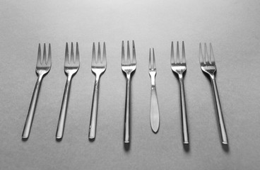 Different forks on grey background. Uniqueness concept