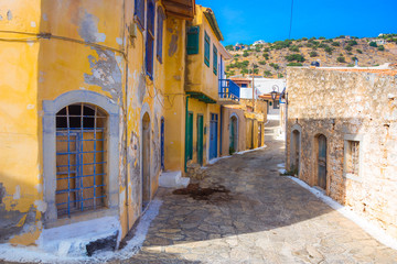Fototapeta na wymiar Narrow street with colorful stone houses in the old village of Pano Elounda, Crete, Greece. 