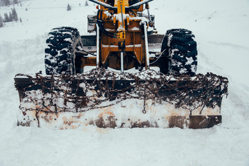 Old snow plow cleaning roads covered in snow up in the mountains.