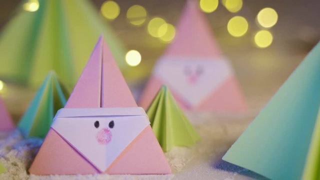 Origami Xmas scene with a pink Santa claus and crhistmas trees in paper craft