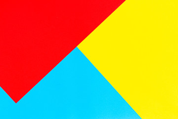 Color papers geometry flat composition background with yellow red and blue tones