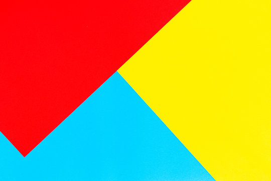 Color papers geometry flat composition background with yellow red and blue tones