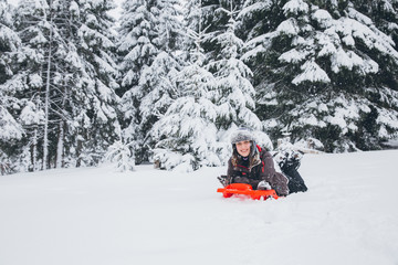 Woman having fun in heavy snow with a sleigh.