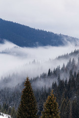 Beautiful rising fog in winter mountain landscape.