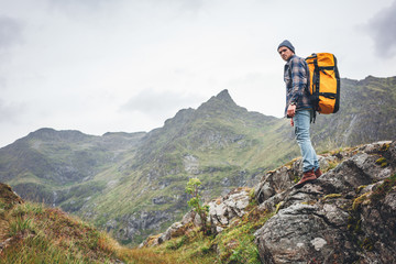 Alone man expeditor wearing professional backpack standing  mountain looking away. Lifestyle adventure vacation