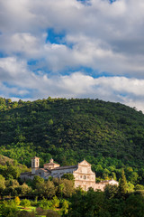 Fototapeta na wymiar Scenic view of St Peter extra moenia ancient church in beautiful Spoleto countryside with clouds above and sunset light