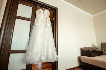 composition - a wedding dress on a gray blue wall with decor and accessories. The concept of marriage, family relationships, wedding paraphernalia.