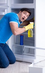 Man cleaning fridge in hygiene concept