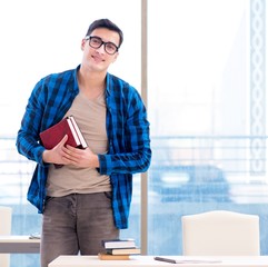Student studying in the empty library with book preparing for ex