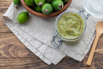 Fresh feijoa jam in a glass jar on the wooden background